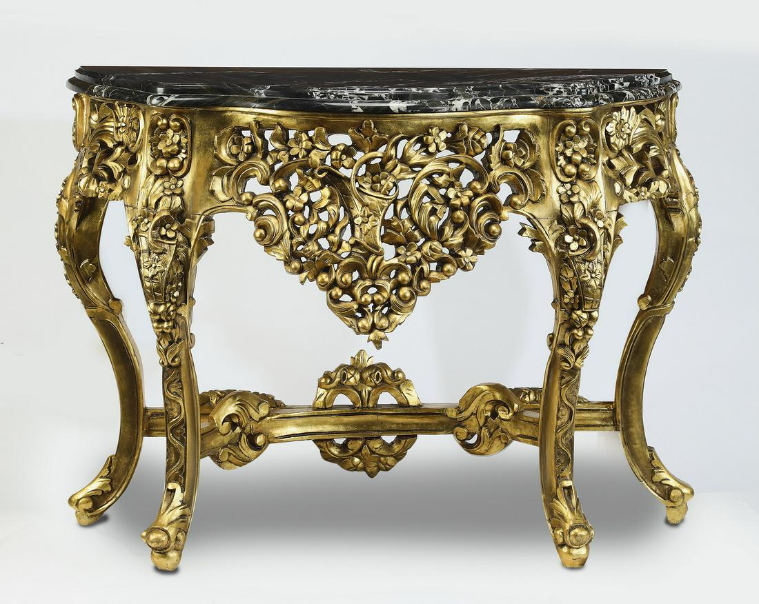 Marble and giltwood demi-lune console: Marble and giltwood demi-lune console in the Rococo taste, having a black marble demi-lune top above a conforming body, with a wide pierce carved apron of C-scrolls, berries, and flowers, intertwined 