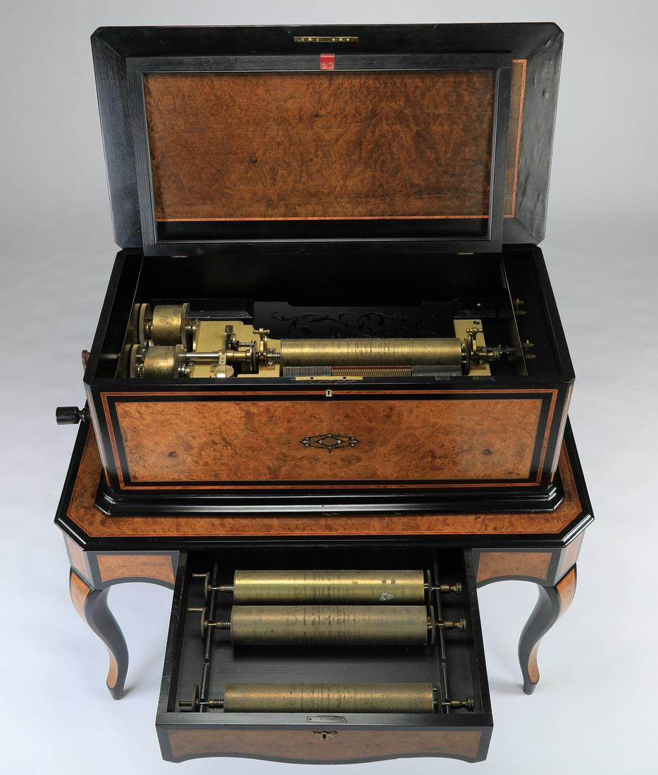 19th c. restored Swiss cylinder music box: Rare and unusual 19th century restored Swiss cylinder music box with orchestreon organ in a satinwood and ebonized case with brass and mother-of-pearl inlays on matching table-style stand. Stand has a