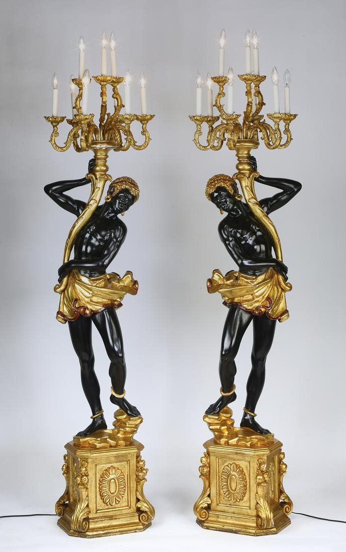 (2) Venetian style carved blackamoor torchieres: Pair of Venetian style carved blackamoor torchieres, ebonzed and parcel gilt, each having a 9-light gilt candelabra with scrolling and acanthus decorated arms, emerging from a torch held by the figure