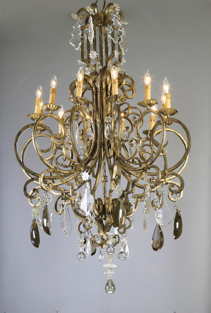 Continental crystal and iron 12-light chandelier: Continental clear and smoky crystal 12-light iron chandelier in the Louis XV taste, having a 'C' scroll crown terminating to French pendants, surmounting a cage standard issuing twelve scrolling arms 