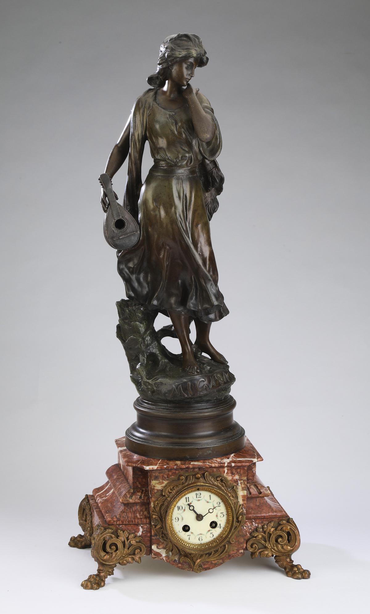 Louis XV style figural mantel clock, ca 1900: Louis XV style figural mantel clock, executed in cast metal and rouge marble, circa 1900, having a patinated metal sculpture 'Mignon' after Luca Madrassi, holding a lute and standing atop a rouge marb