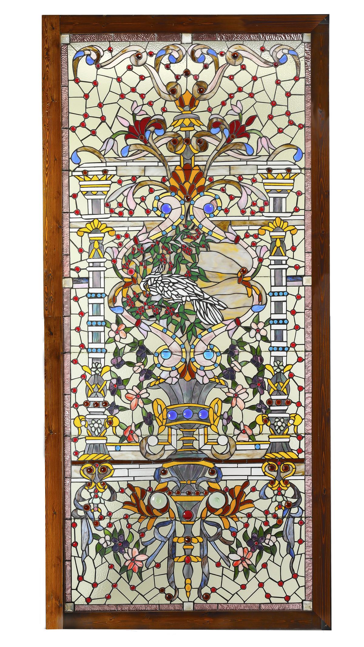 American art glass landing window: Victorian-style beveled and stained glass landing window handcrafted by Roger Wandry (American, 1946-2001), featuring a clear glass ground accented with red and blue jewels, and centered by a scene of