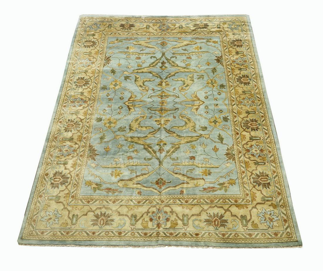 Hand knotted wool Indo-Oushak carpet, 12 x 9: Hand knotted wool Indo-Oushak carpet, having a full field of sickle leaves, vines, and flowers in cream, taupe, and chocolate on a light blue ground, with an alternating palmette border on a cream fie