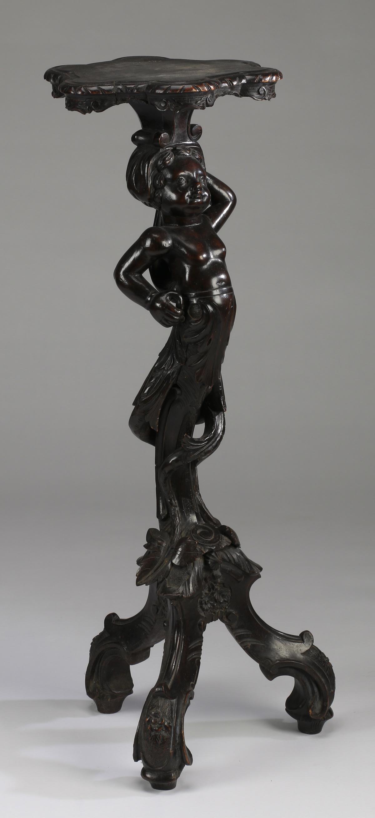 Rococo Revival figural fern stand: Italian Rococo Revival ebonized hardwood fern stand, having a petal form top surmounting a carved and pierced putto term figure terminating in an acanthus 'C' scroll support twined with leaves and ten
