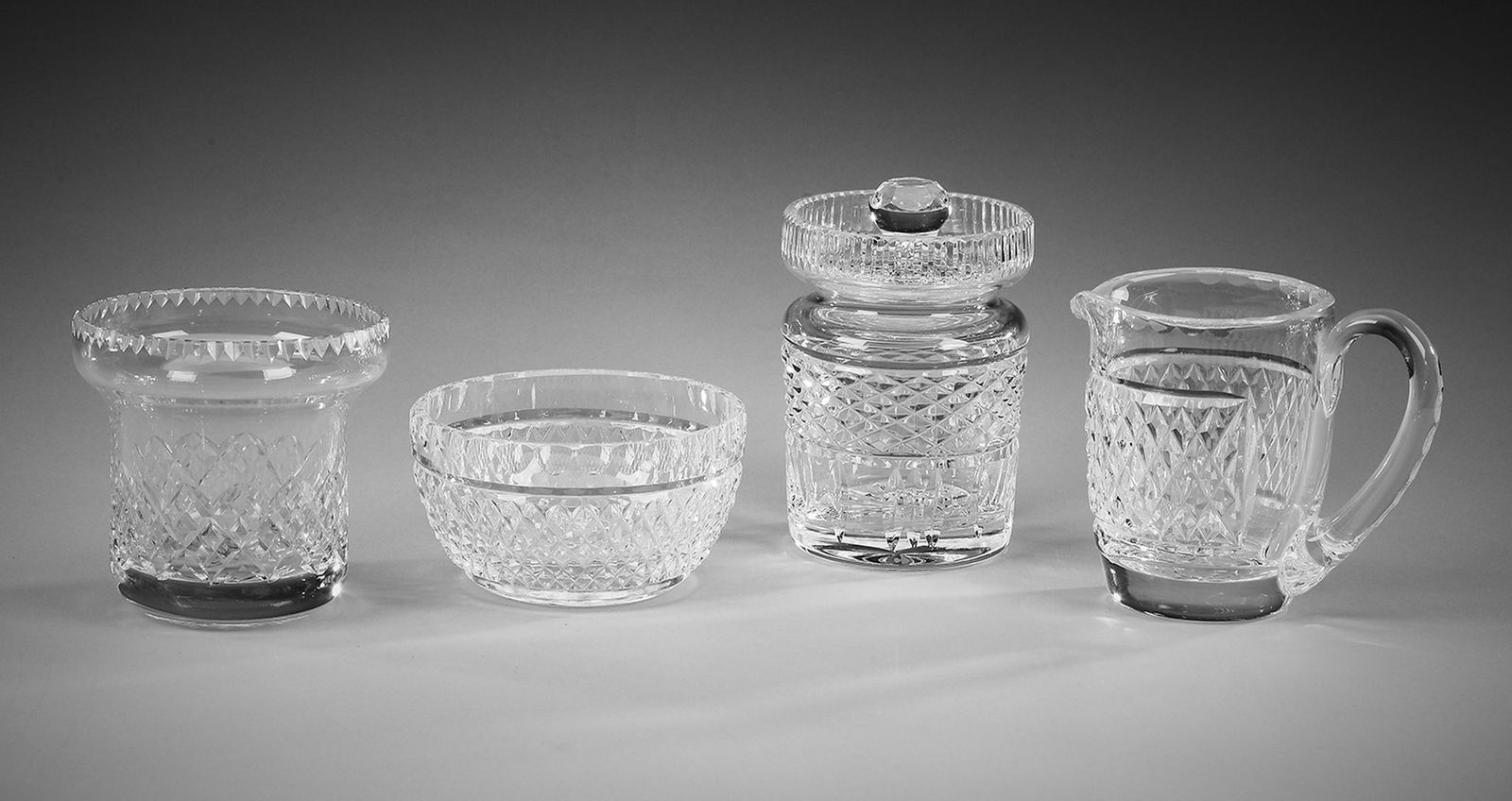 Waterford crystal 'Alana' table accessories: Waterford crystal table accessories in the 'Alana' pattern, comprising: (1) jam pot; (1) creamer; and (1) sugar, each piece with a honeycomb etched pattern, marked Waterford underneath; together with