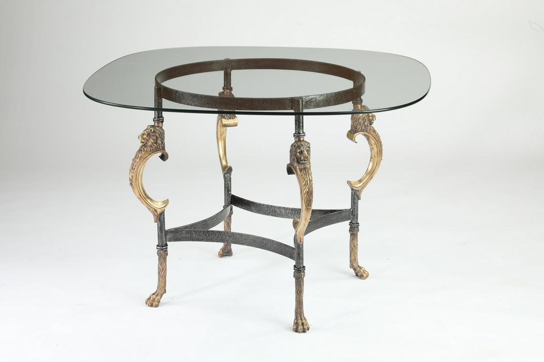 Maitland-Smith style glass top accent table: Maitland-Smith style accent table, having a glass surface rising on the bronze and iron base, accented with lion maks, terminating to hairy paw feet connected by stylized box form stretchering, 28.75"