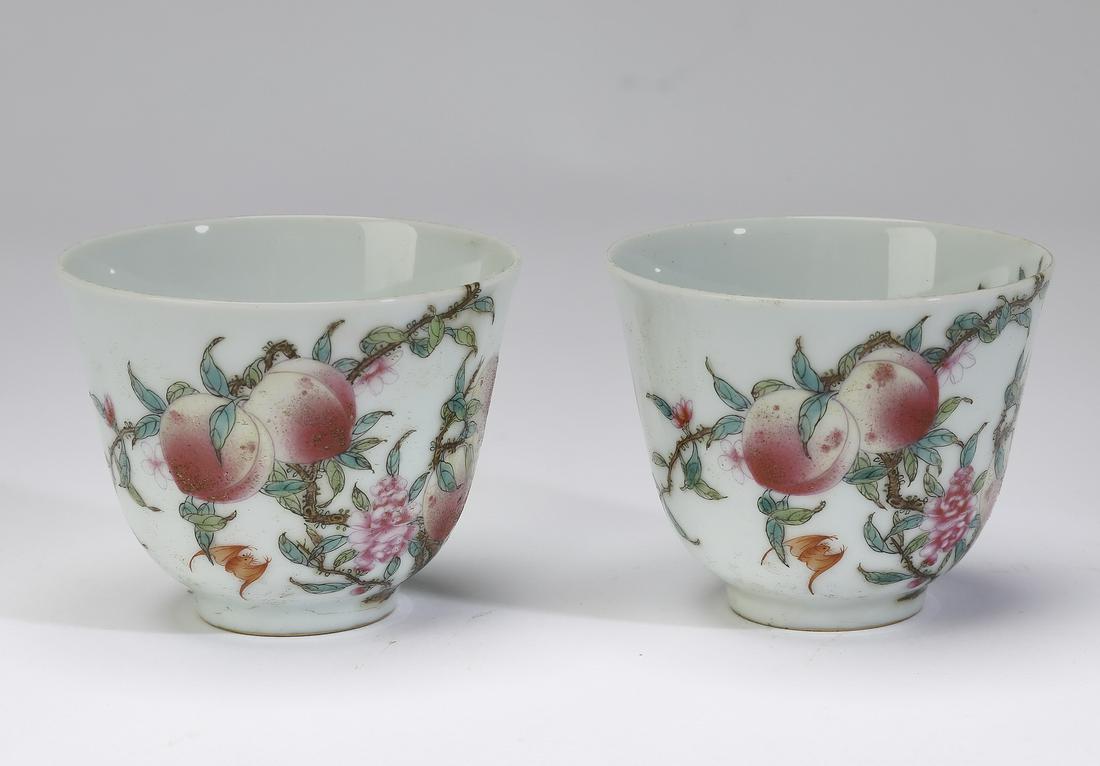 (2) Chinese peach and bat tea cups: Pair of Chinese famille rose tea vessels, each having two bats and a prunus branch on the interior, the exterior decorated with five peaches and three bats, the undersides having blue underglaze six c