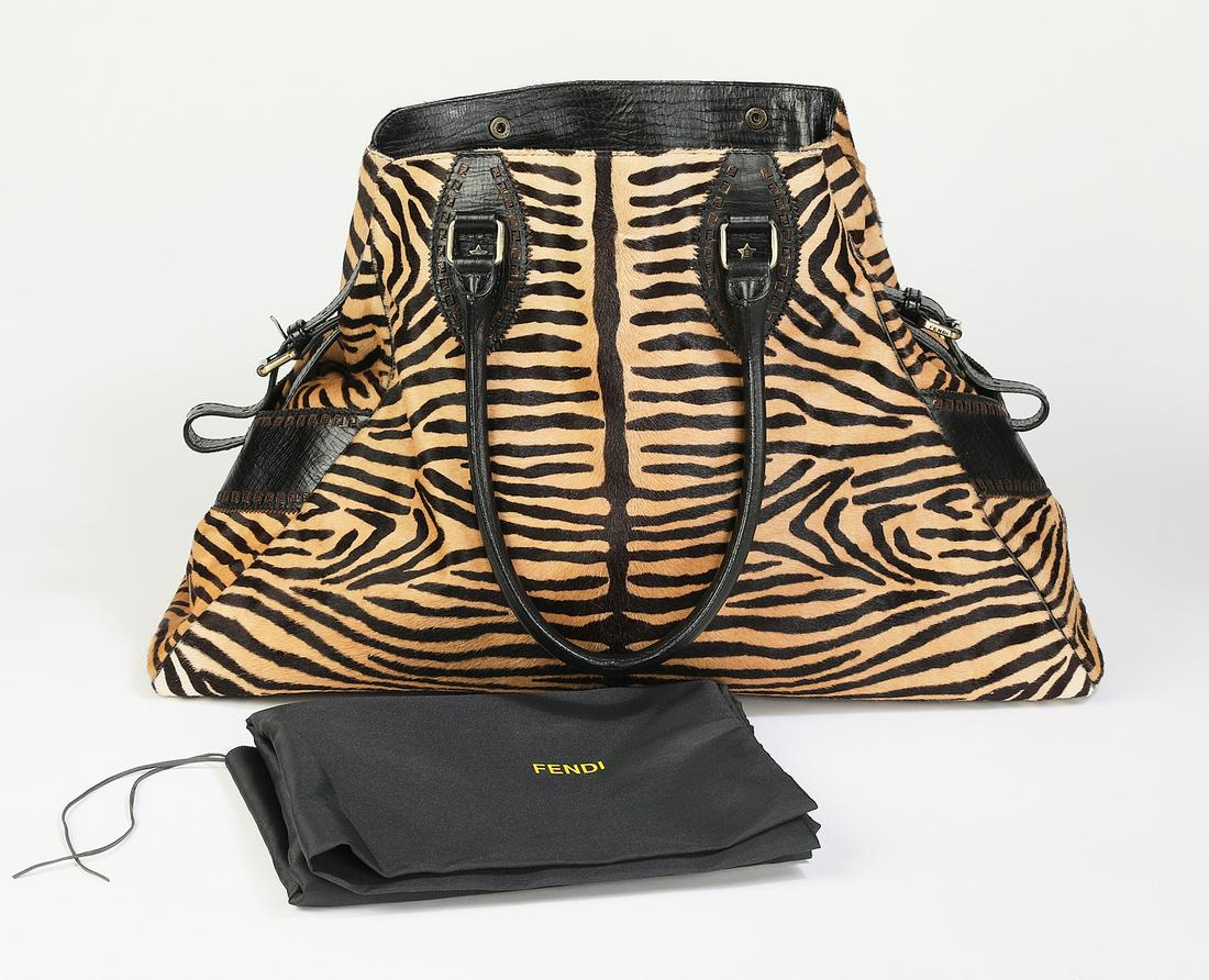Authentic Fendi tiger print calf hair and leather bag: Authentic Fendi tiger print calf hair and leather bag, having dual rolled straps, buckle side adjustments, and ruthenium hardware, the snap closure opening to Zucca lining with a single pocket, serial