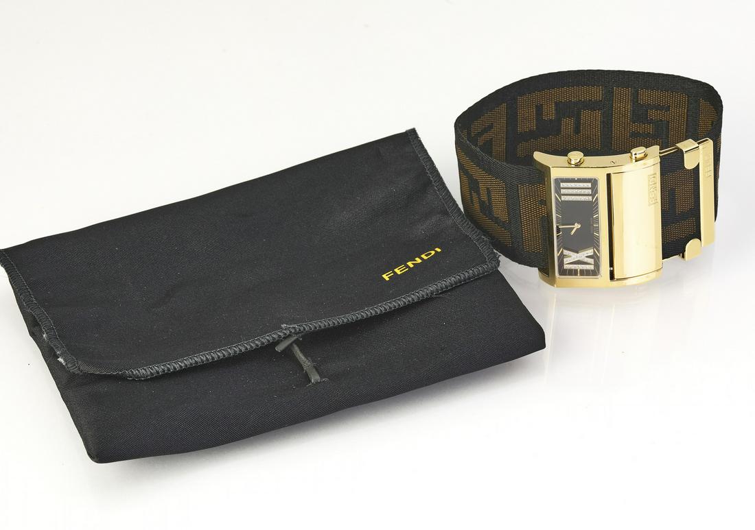Fendi yellow gold plated Zip Code watch w/ pouch: Fendi yellow gold plated stainless steel 'Zip Code' watch, 1130G, having a 46mm x 36mm rectangular case with a black dial marked by large Roman numerals at 3 and 9, attached to an 1.50"w. zucca canvas