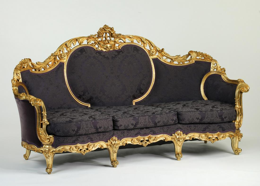 Extravagant Italian carved giltwood settee: Extravagant Italian giltwood settee, having a pierce carved crest leading to curved arms, centering the damask back and drop-in seat cushions, the exterior upholstered in velvet, terminating to cabrio