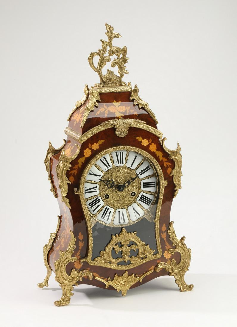 Louis XV style marquetry bracket clock by Hermle: Louis XV style marquetry bracket clock by Franz Hermle, mid-20th century, having a gilt metal rocaille finial surmounting a cartouche case inlaid with polychrome floral marquetry, centering an enamel