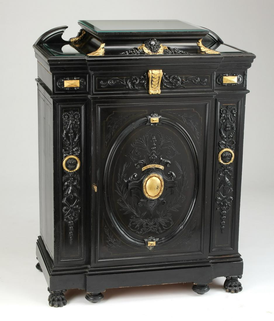 French Empire style carved and ebonized cabinet: Early 20th century French Empire style ebonized cabinet, the stepped top with broken crest and three conforming mirror panel toppers, above the conforming one door case centering a gilt corbel leading