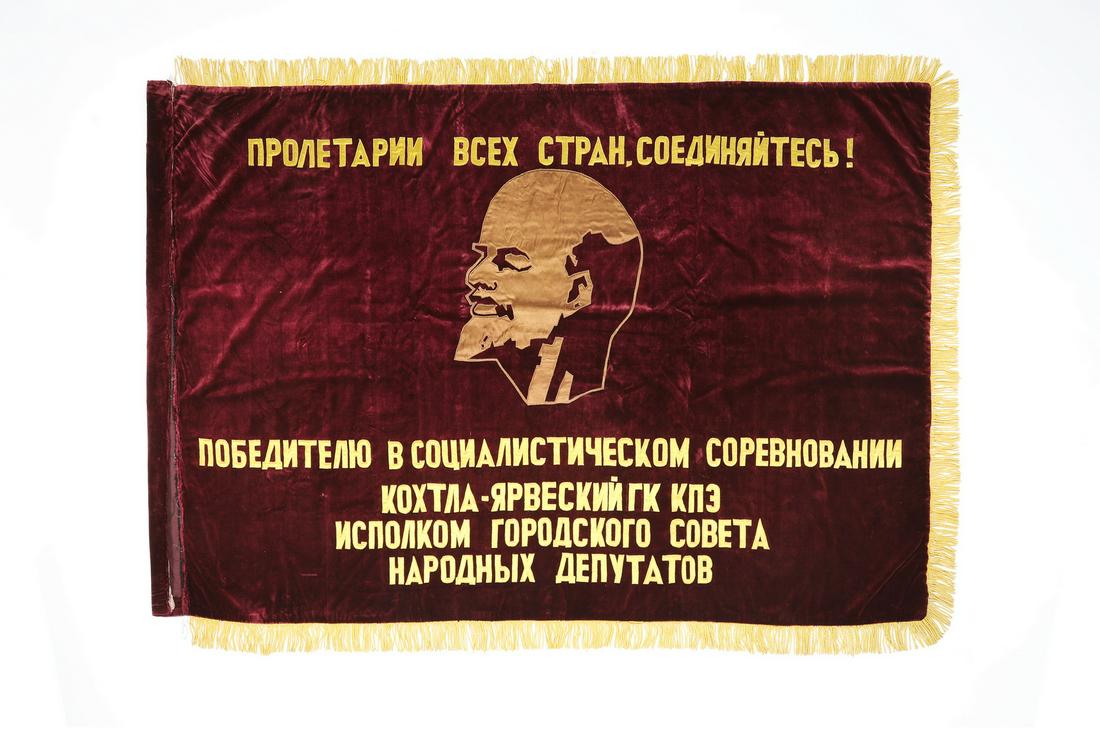 Communist era propaganda banner with bust of Lenin: A political propaganda flag or banner associated with the City of Kohtla-Järve in Estonia, early 20th century, made of red velvet and appliqued with yellow silk lettering, having the Marxist slogan,