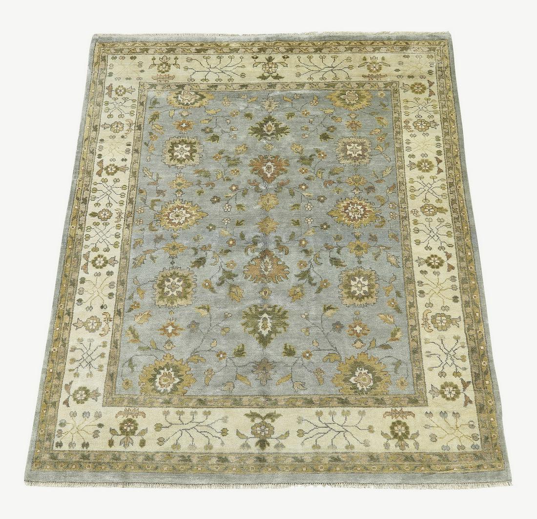 Hand knotted wool Indo-Oushak, 10 x 8: Hand knotted wool Indo-Oushak, having a full field of palmettes and stylized floral elements in taupe, sage, rust, and cream on a slate blue field, with an alternating rosette border on a cream ground
