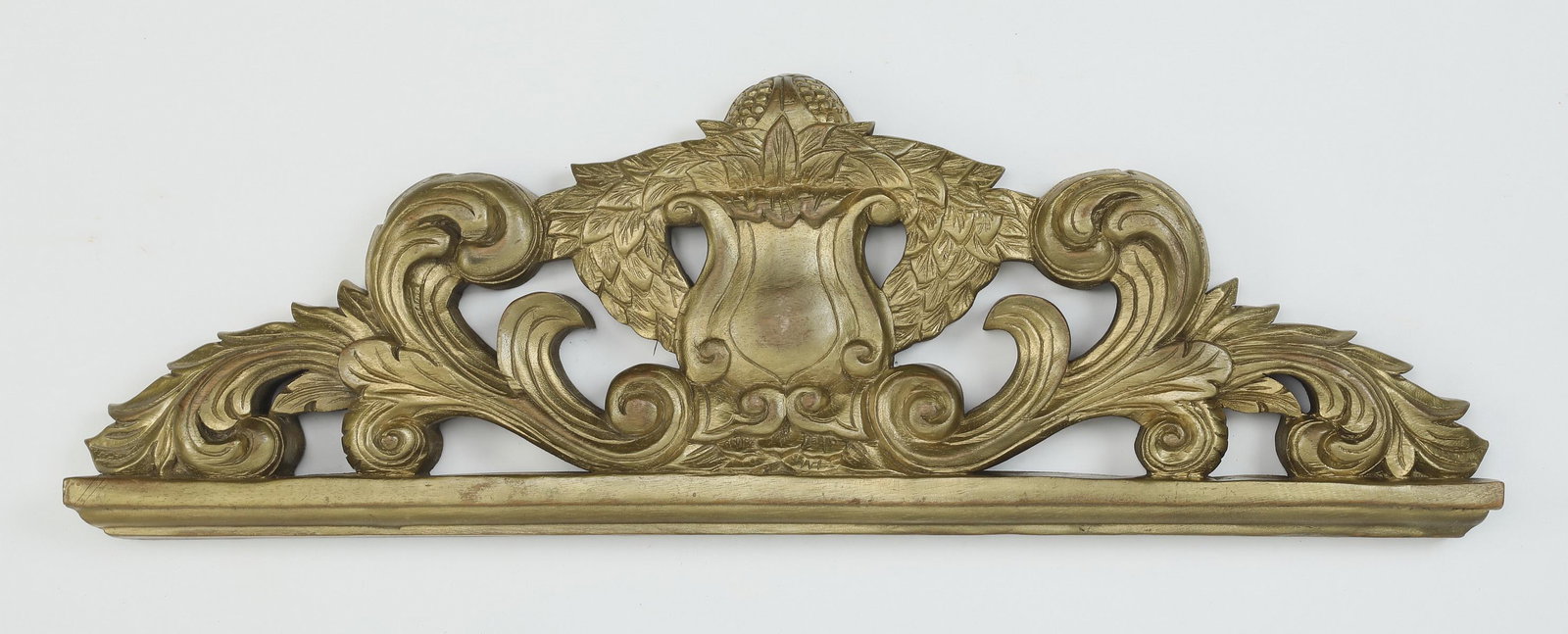 Carved and gilt architectural element: Carved and gilt architectural element, centering a shield and wreath flanked by acanthus scrollwork, 11.75"h x 36"w x 2.5"d.