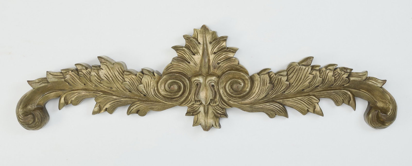 Carved and gilt architectural element: Carved and gilt architectural element, centering a leaf form finial flanked by scrolling acanthus arms, 10"h x 36"w x 2"d.
