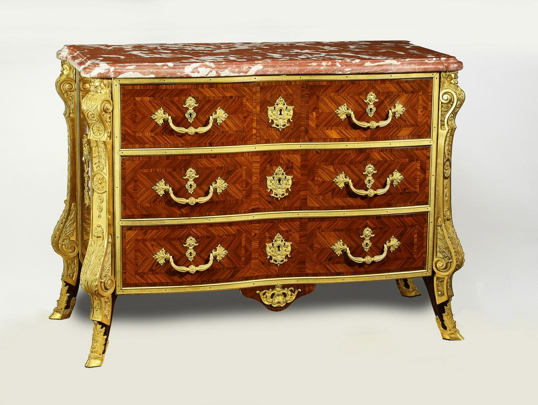 Empire style bronze mounted marble top commode: Empire style bronze mounted commode, having a rouge marble surface rising on the gilt bronze mounted chest of two short drawers and two long drawers, inlaid with walnut and satinwood, flanked by scrol