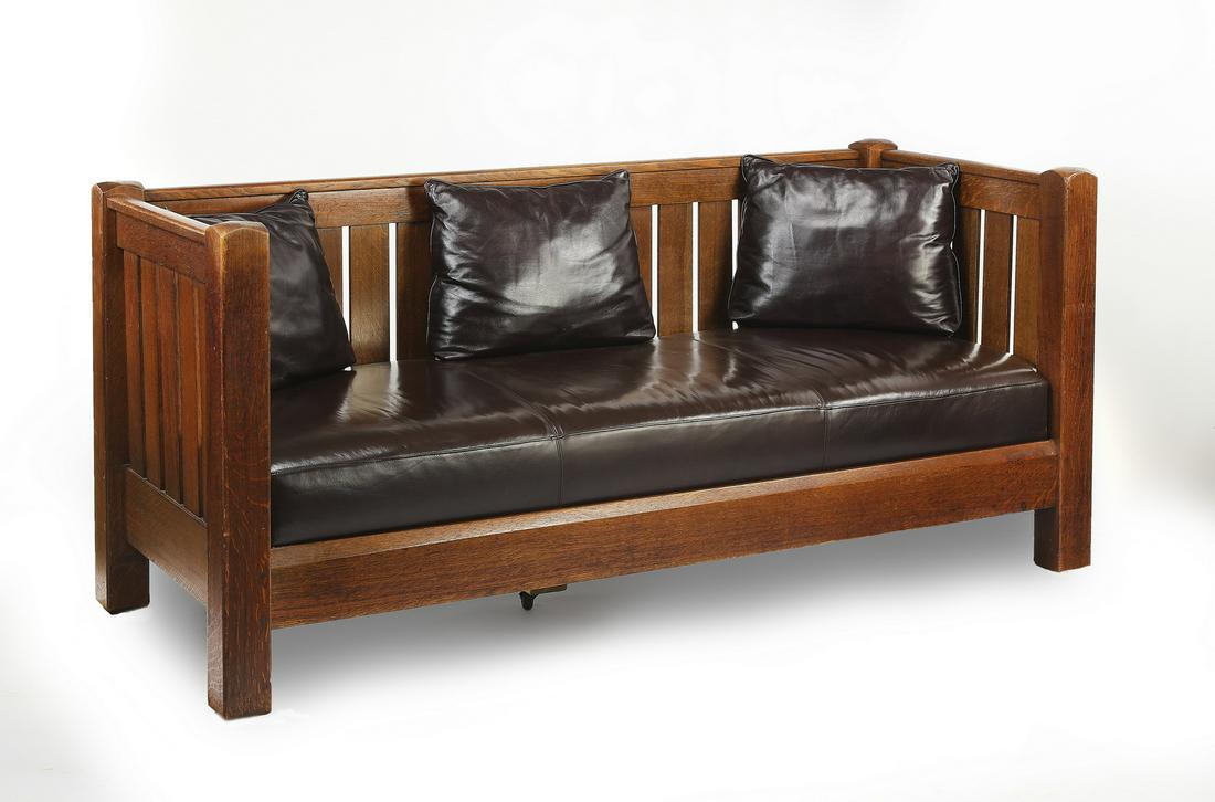 L & J. G. Stickley continuous arm oak settle, 76"w: L. & J.G. Stickley continuous arm settle, circa 1912-1917, executed in carved oak and leather, having an all-around plank design, rising on block legs, together with a leather seat cushion and three l