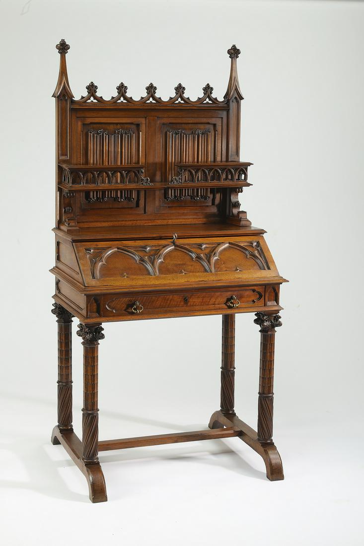 19th c. French Gothic Revival style walnut secretary: French Gothic Revival style walnut secretary, late 19th century, having an upper shelf with a pierce carved gallery and linen fold backsplash rising on a relief carved slant top, sliding forward to re