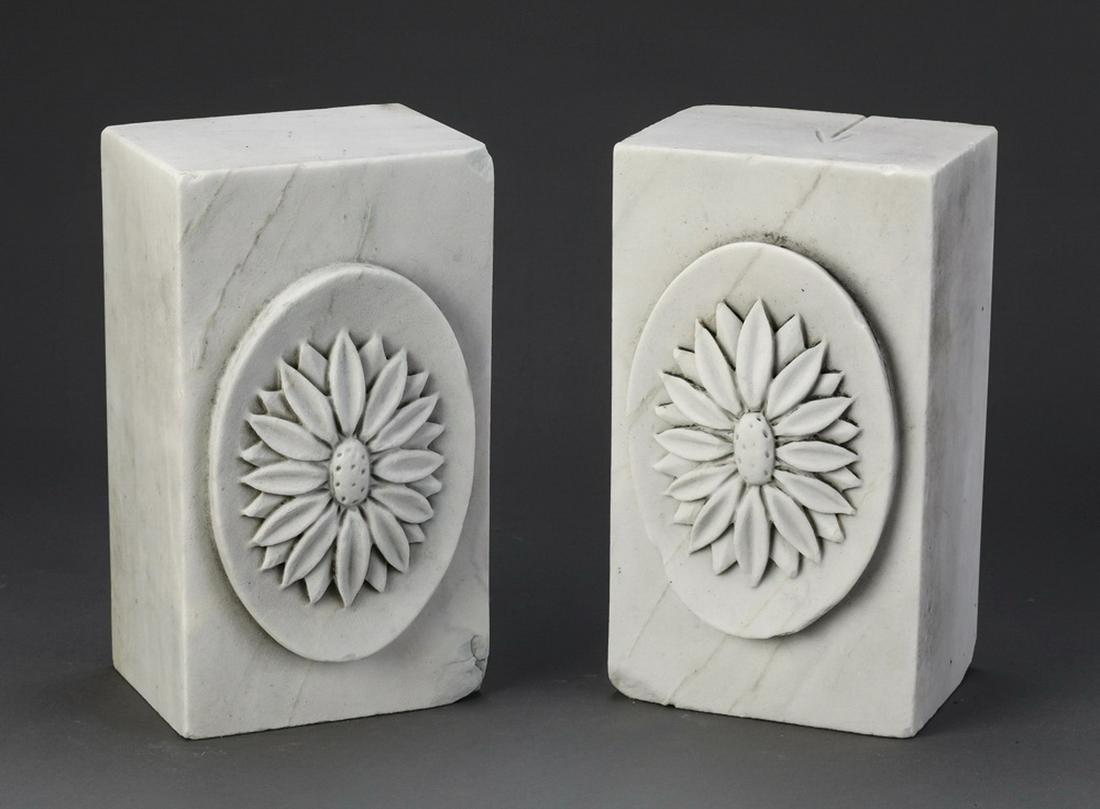 (2) Continental carved marble floral blocks: Pair of Continental carved marble architectural elements, early 20th century, each of rectangular form centering a relief carved oval floral rosette, 9"h x 5"w x 4"d.