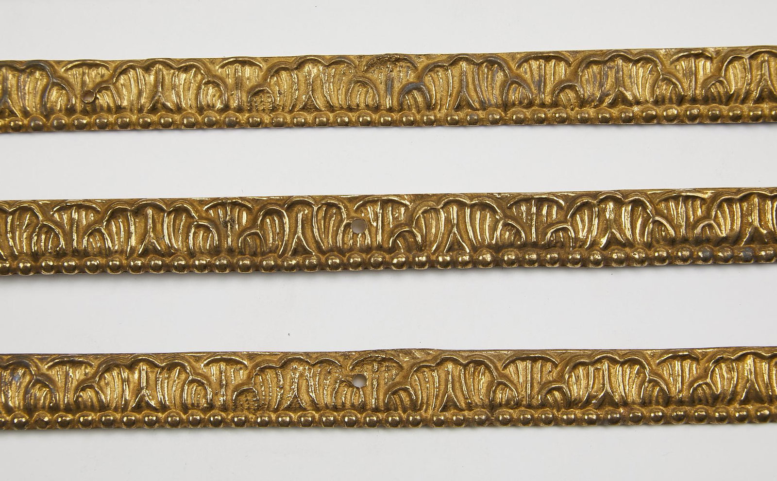 (10) Acanthus leaf pattern bronze trim moldings: Group of (10) bronze trim moldings, each decorated with a repeating pattern of acanthus leaves, 17.75"l x 0.5"w x 0.25"d.