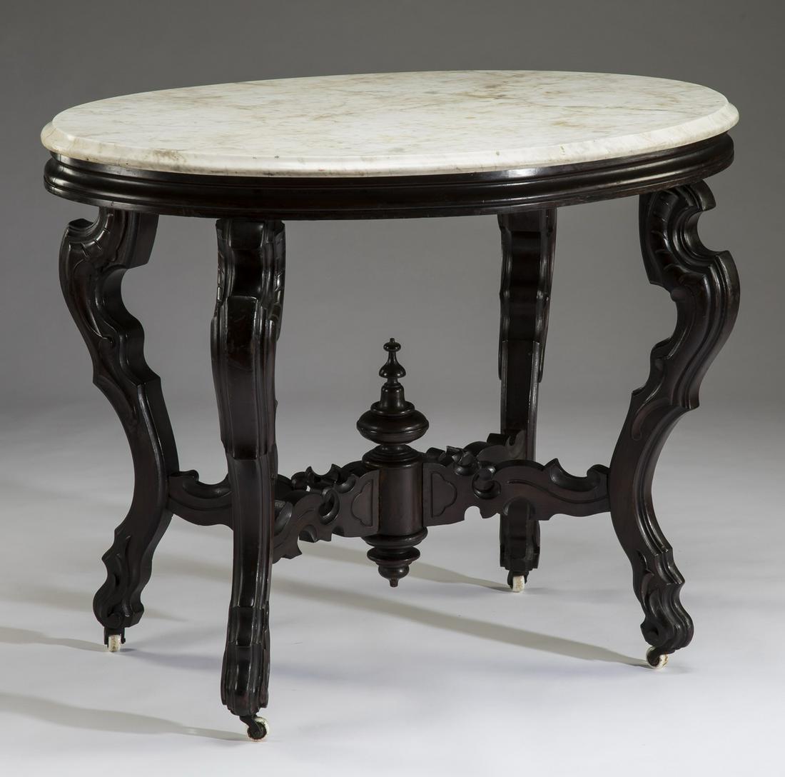 19th c. American rosewood marble top center table: American Renaissance Revival rosewood center table, 19th century, having an oval white marble top, surmounting a molded apron, rising on carved cabriole legs joined by a baluster topped 'X' stretcher,