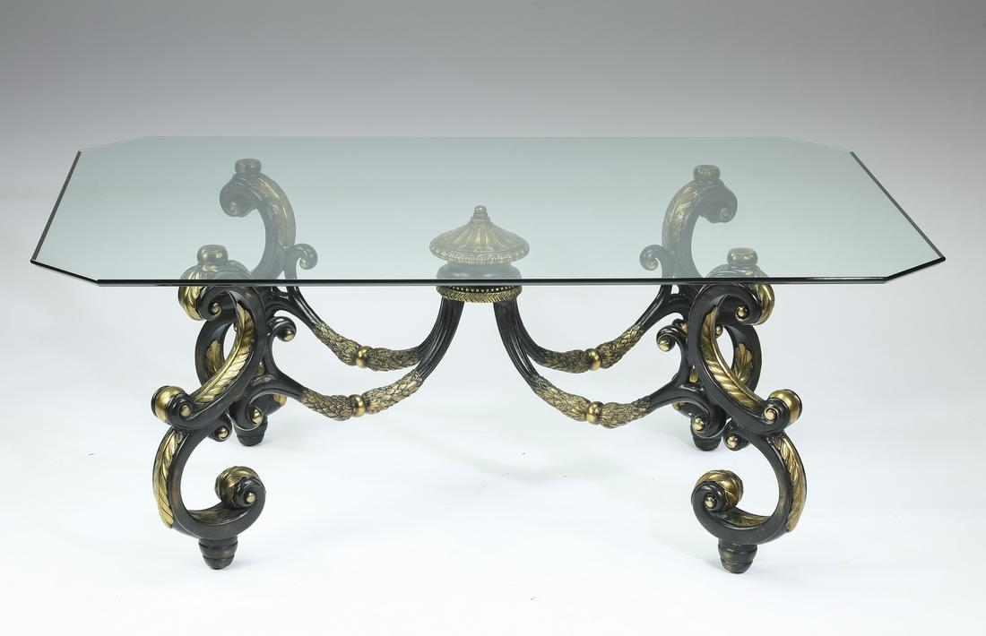 Bronze and glass coffee table: Bronze and glass coffee table, having a glass surface with canted corners, rising on four ebonized and parcel gilt bronze scrollwork legs connected by X-form stretchering, terminating in toupie feet,