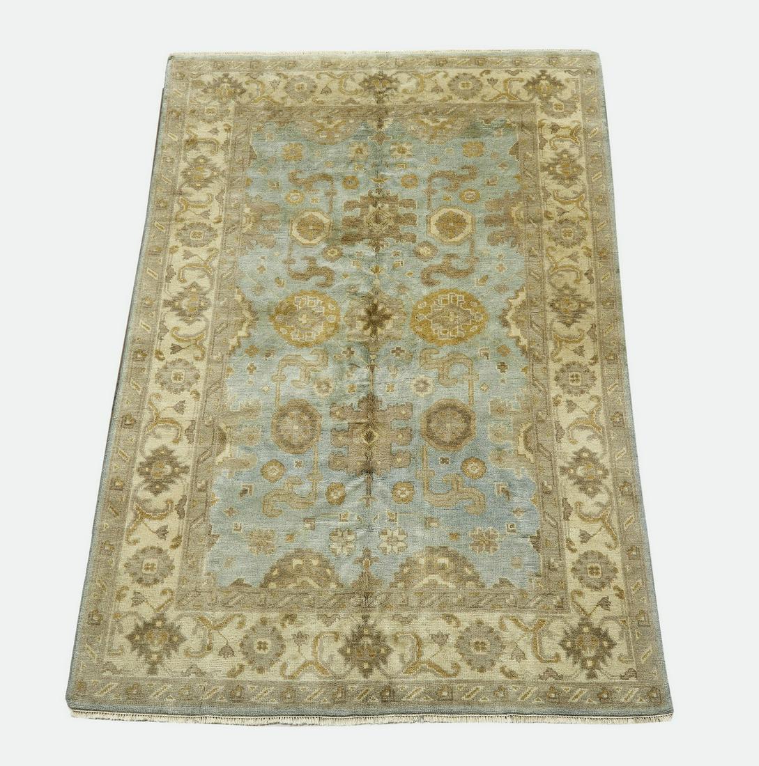 Hand knotted wood Indo-Oushak carpet, 9 x 6: Hand knotted wood Indo-Oushak carpet, having a full field of palmettes, flowers, and sickle leaves in cream, taupe, and tan on a light blue ground, with an alternating palmette border on a cream field