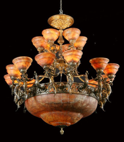 Bronze and alabaster chandelier: Empire-style 18-light bronze reticulated chandelier with winged maiden term figures, each holding a torch with an alabaster shade, 66"h.