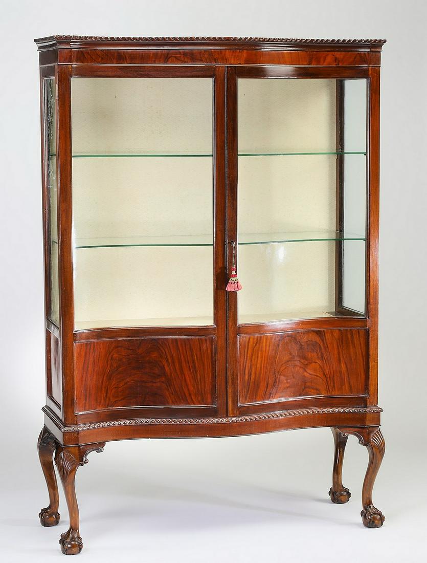 Early 20th c. Queen Anne style mahogany cabinet: Queen Anne style mahogany cabinet, early 20th century, having a scalloped cornice surmounting the conforming cabinet, with glazed and paneled doors opening to three shelves, the whole rising on cabrio