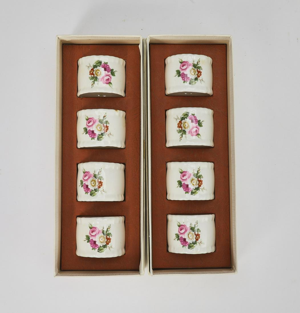 (8) Coalport Fine Bone China napkin rings: Set of (8) Coalport Fine Bone China napkin rings, depicting foliate medallions on a white ground, together in their two original boxes, each measuring 1.25"h x 1.75"dia.