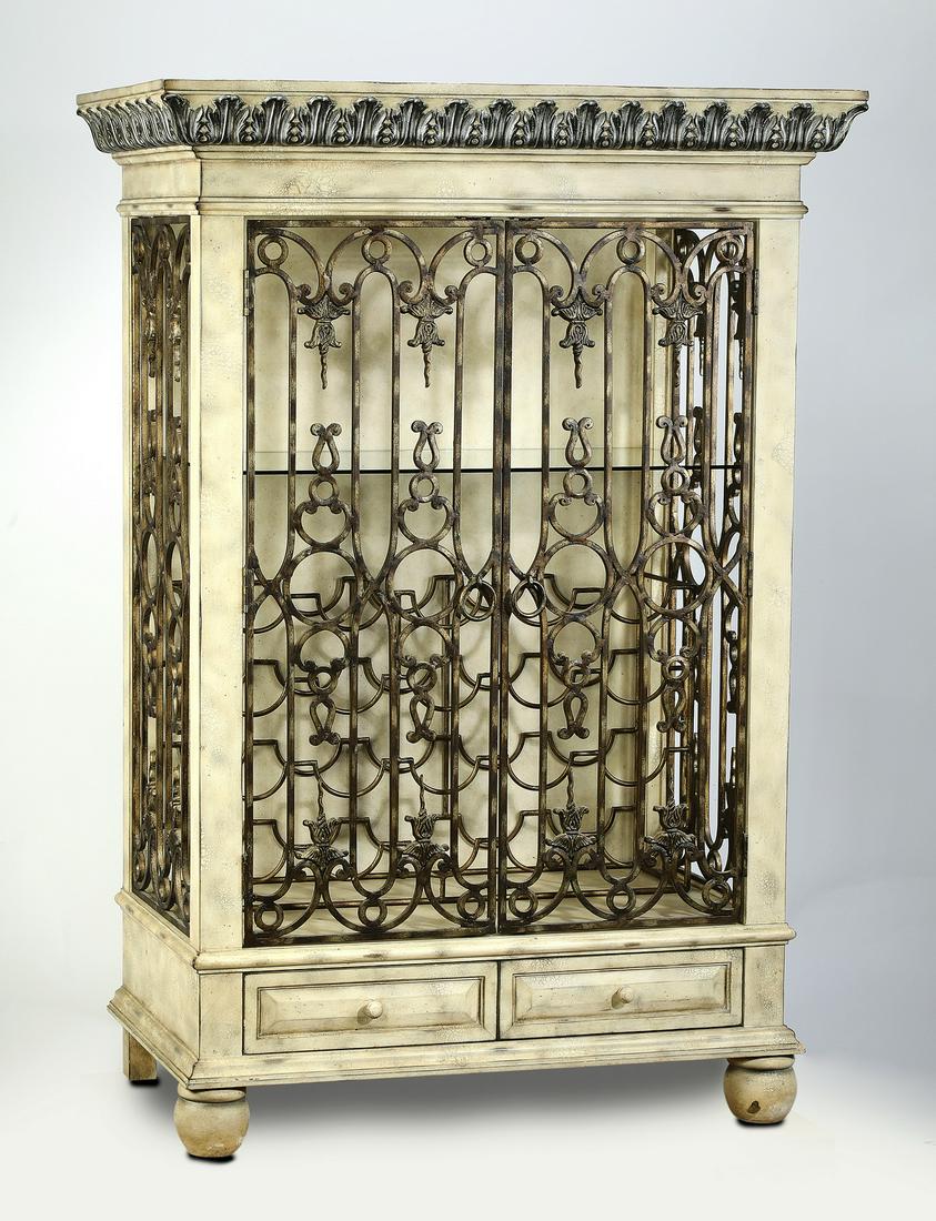 Bar and wine cabinet with wrought iron panels: Bar cabinet in the French taste, executed in paint decorated wood and wrought iron, having a foliate cornice above a wood framed iron trellis door, opening to a glass shelf and wrought iron wine stora