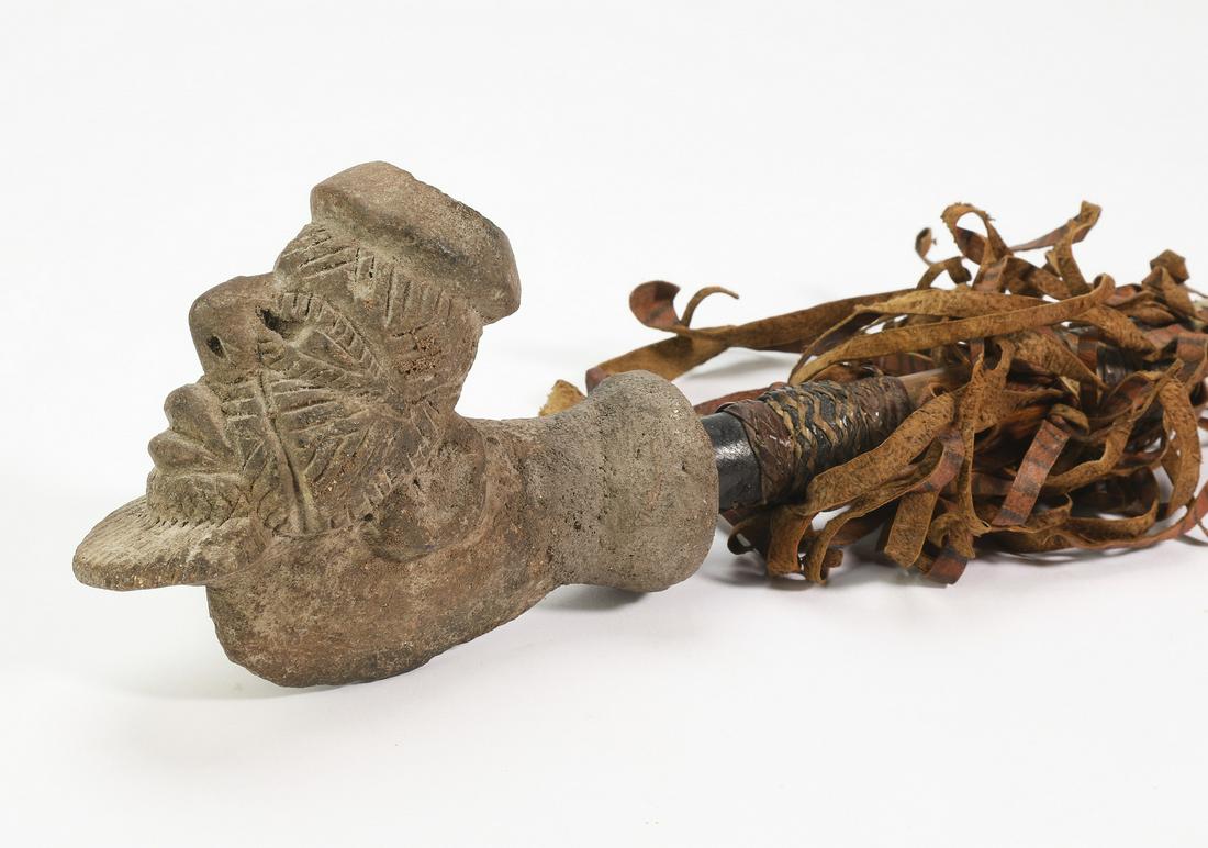 Bamum ceremonial pipe, Cameroon, 24"l: Bamum ceremonial pipe, Cameroon, having a figural earthenware bowl depicting a male dignitary with scarification, connected to a leather wrapped wood stem, with leather fringe embellishment, 3.75"h x 