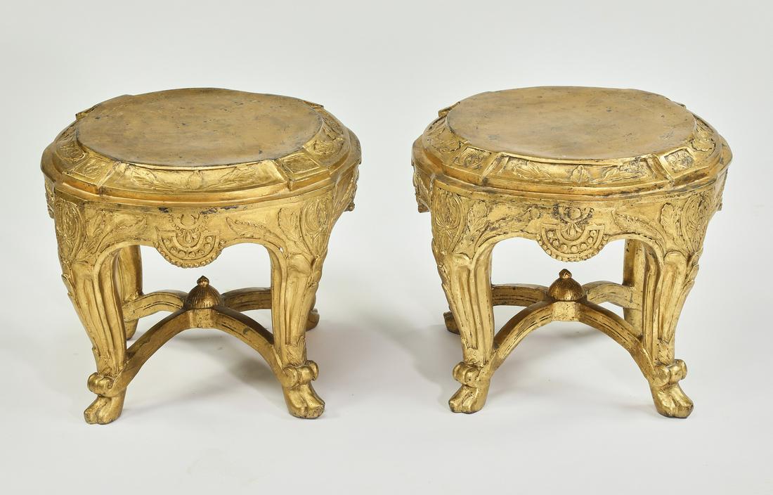 (2) Gilt cast iron tuffets, 16"h: Pair of giltcast iron tuffets, of circular form, rising on cabriole legs joined by an 'X' stretcher and terminating to paw feet, 15.5"h x 18"dia.