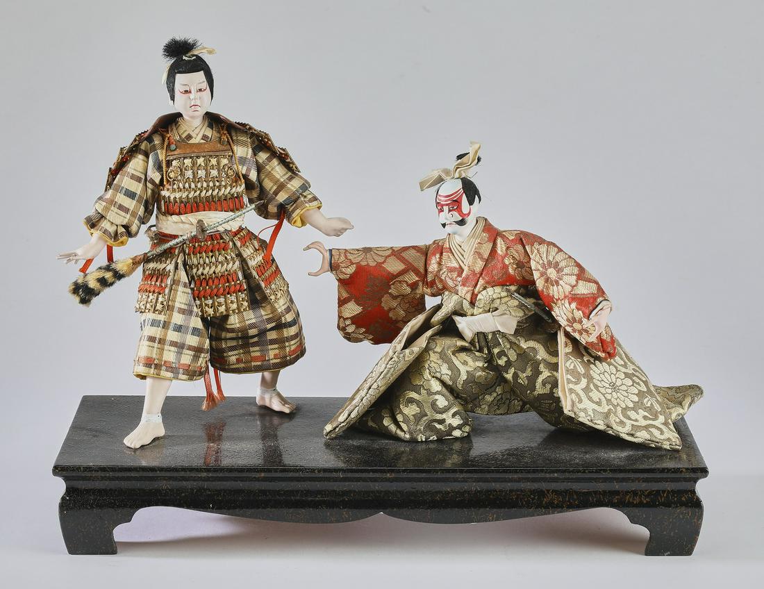 (2) Japanese gofun takeda ningyo dolls: Pair of Japanese takeda ningyo dolls, likely Early Showa Period, circa 1926-1945, of Kabuki theater actors in elaborate makeup and silk costumes, the taller measuring 9"h x 7"w x 4"d, the smaller meas
