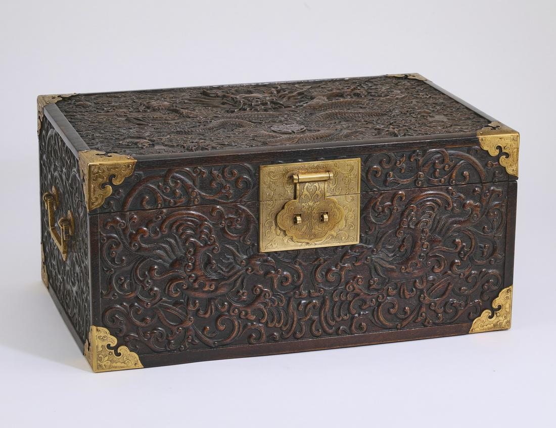 Chinese carved zitan dragon chest, 17"w: Chinese gilt bronze mounted zitan dragon chest, the hinged rectangular lid carved with a five clawed writhing dragon holding a flaming pearl of wisdom and intertwined around a Shou character amidst au