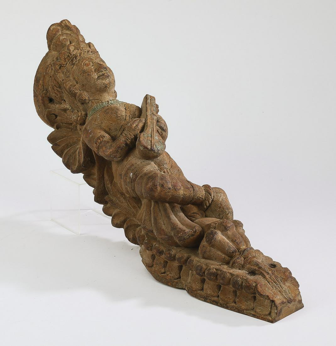 Balinese carved wood figural bracket, 22"l: Balinese carved wood figural bracket, mid-20th century, depicting a female musician holding an instrument, 22"l x 4"w x 6.5"d.