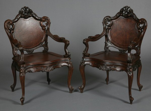 Pair of French Vietnamese rosewood arm chairs: Pair of early 20th century Louis XV-style French Vietnamese carved rosewood arm chairs, the cartouche shaped and paneled back sweeping to foliate carved arms, raised on cabriole legs, 41.5"h x 25"w x 