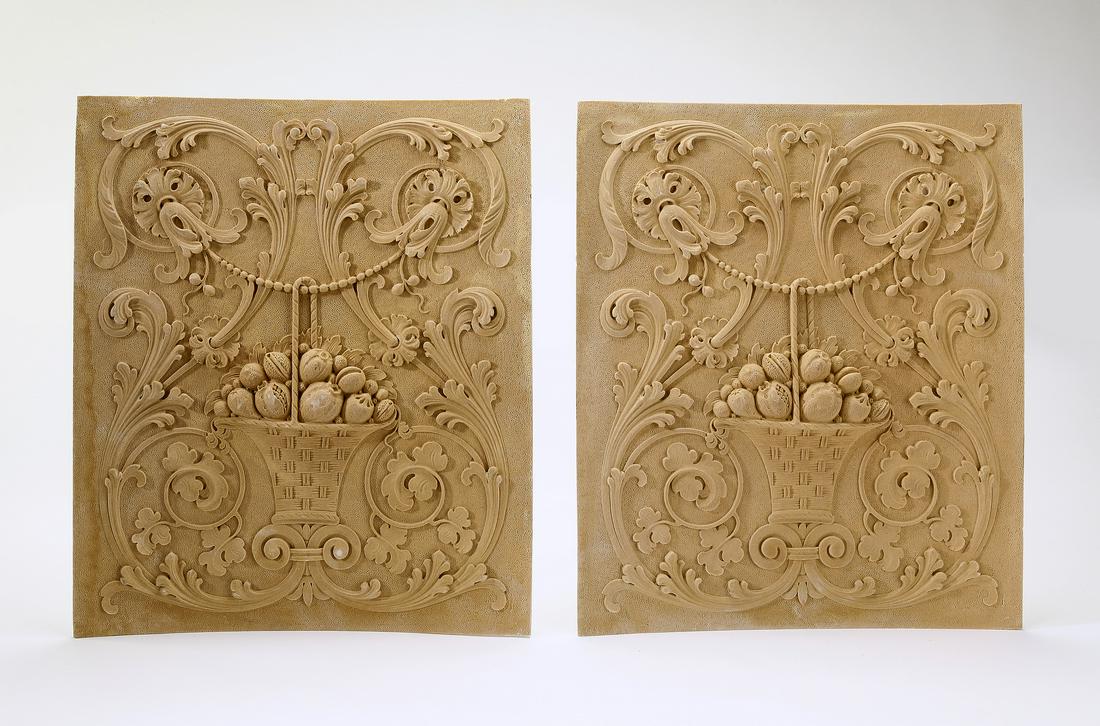(2) Rococo style architectural panels, 19"h: Pair of architectural panels, crafted of cast composition, depicting elaborate acanthus scrollwork centering a basket with an abundant fruit arrangement, ready for your stained or painted finish, 19"h