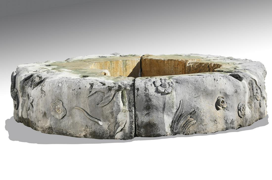 Carved Italian limestone surround: Carved Italian limestone surround, comprised of (6) curved elements relief carved with shells and fish, together forming a ring, overall dimensions 20"h x 104"dia, interior dimensions 41"dia.