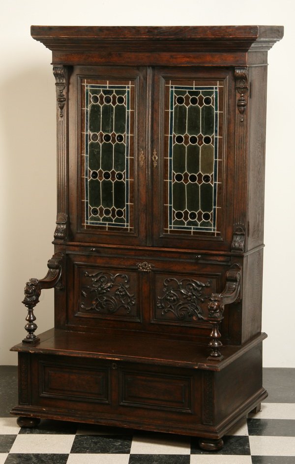 19th c. Jacobean-style hall bench bookcase: Very rare and unique 19th century 2-part English Jacobean-style hall bench bookcase with leaded glass doors, lift top seat, and hidden storage compartment behind a drop front carved panel, 84"h x 45"w