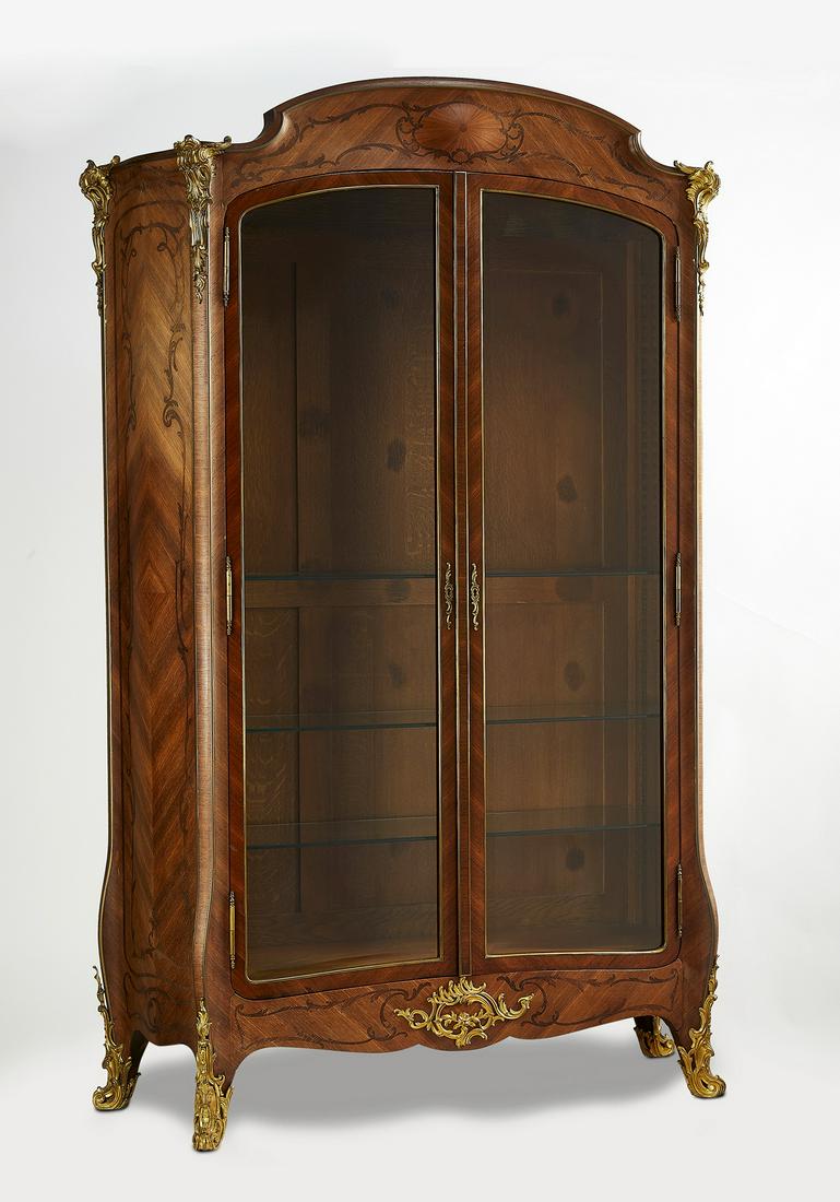 19th c. Napoleon III bronze mounted marquetry vitirne: Napoleon III marquetry inlaid mahogany and satinwood vitrine with gilt bronze mounts, late 19th century, having a shaped pediment with oval cabochon issuing sinuous marquetry inlay flanked by gilt bro