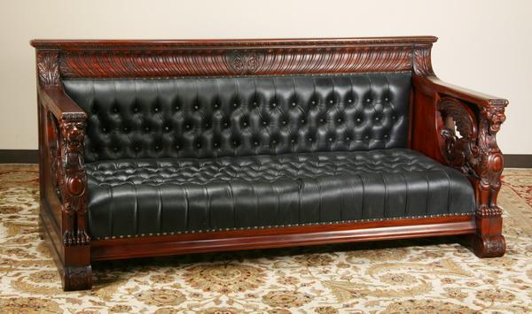 Carved mahogany sofa after R.J. Horner: Oversized carved mahogany sofa with massive winged gryphons supporting each arm, in the style of R.J. Horner, upholstered in tufted black leather with nailhead trim, 38"h x 83"l x 36"d.