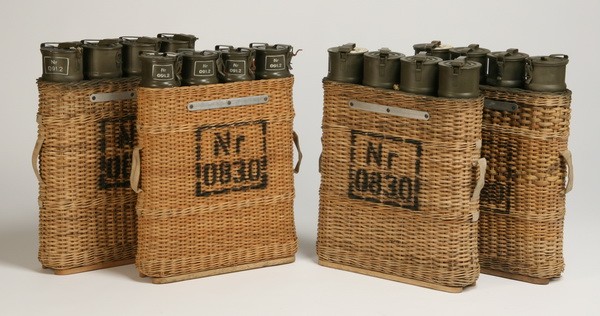 Set of 4 World War II ammunition canisters: Set of four World War II European issue artillery shell casings, housed in 4's, in original wicker carriers, each carrier stamped Nr 0830, each set of canisters with paper label numbered 591-2074, and