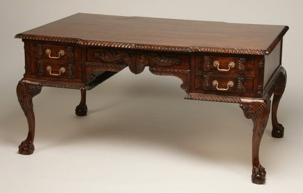 Carved mahogany partners' desk: Carved mahogany Chippendale-style partners' desk with gadrooned edge, concealed central drawer with relief carved foliate front, all raised on cabriole legs terminating in ball and claw feet, 30.5"h x