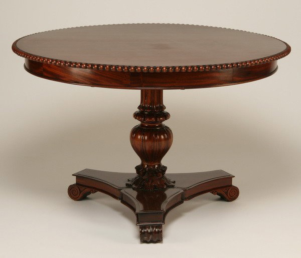 Mahogany tilt top center table: Mahogany tilt top center table with carved baluster shaped standard on a tripod base, 47" diam.