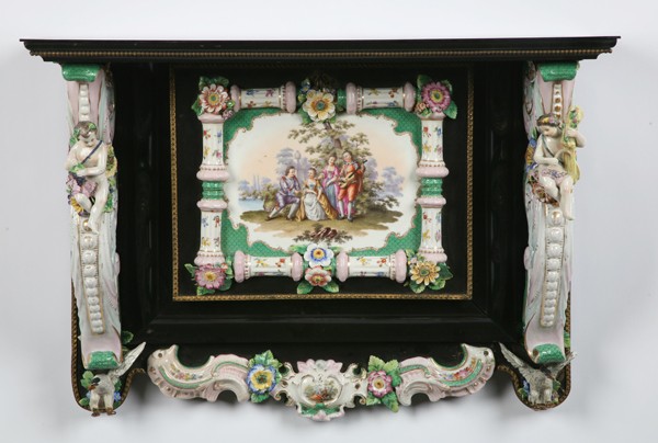 19th c. Meissen key safe: Late 19th century wall mounted German porcelain key safe with central drop front compartment decorated with a romantic gardenscape, flanked by porcelain brackets with seated putti, marked Meissen, 20"