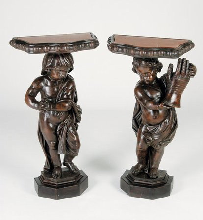 (2) 18th c. Venetian carved walnut pedestals: Pair of 18th century Venetian carved walnut pedestals with lifesize standing putti, one holding a knight's armored glove, the other holding a knight's cloak, each supporting a serpentine shaped marble