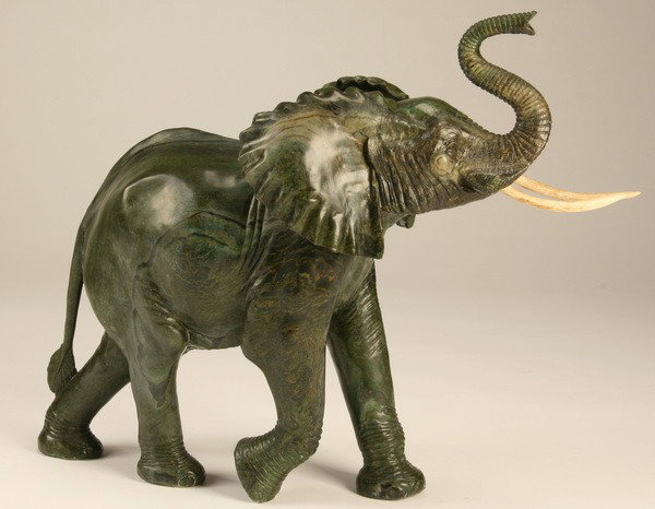 Carved marble elephant: Carved marble elephant with bone tusks, 25"h x 36"l (including the tusks).