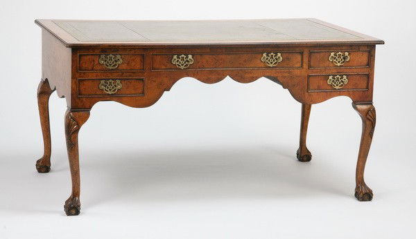Early 20th c. writing desk with leather top: Early 20th century Georgian-style chestnut faux partners' desk with curved apron and gold tooled green leather top, all raised on ball and claw feet, 31"h x 60"l x 36"d.